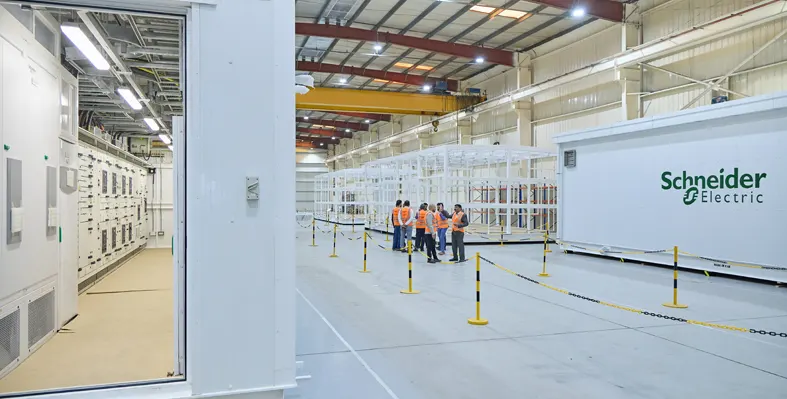 Workers in safety vests inside a large industrial facility