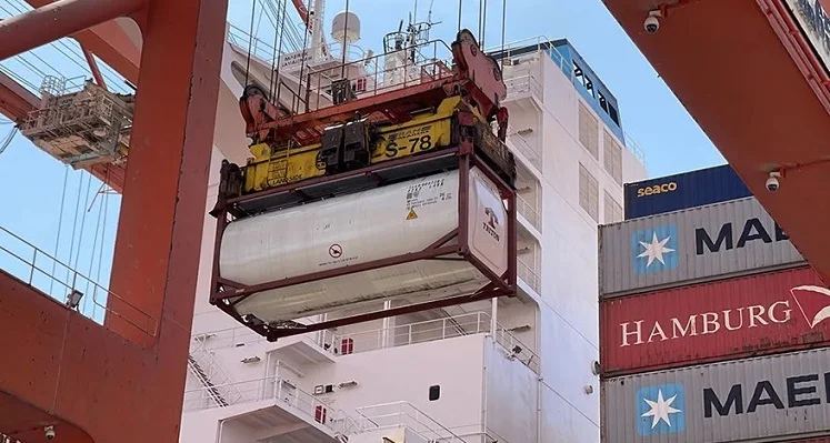 Water tanks being lowered onto a ship.